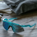 Oakley sport sunglasses with translucent teal frame and blue prizm lens