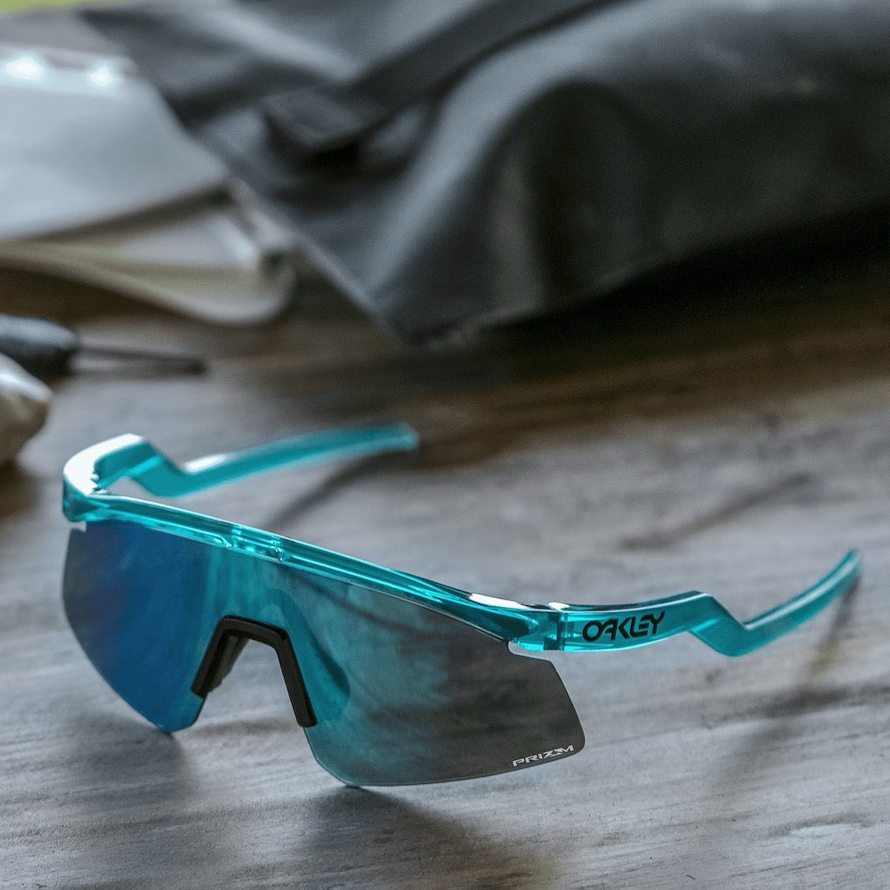 Oakley sport sunglasses with translucent teal frame and blue prizm lens