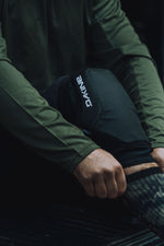 DAKINE black knee pad worn on person's knee in action pose