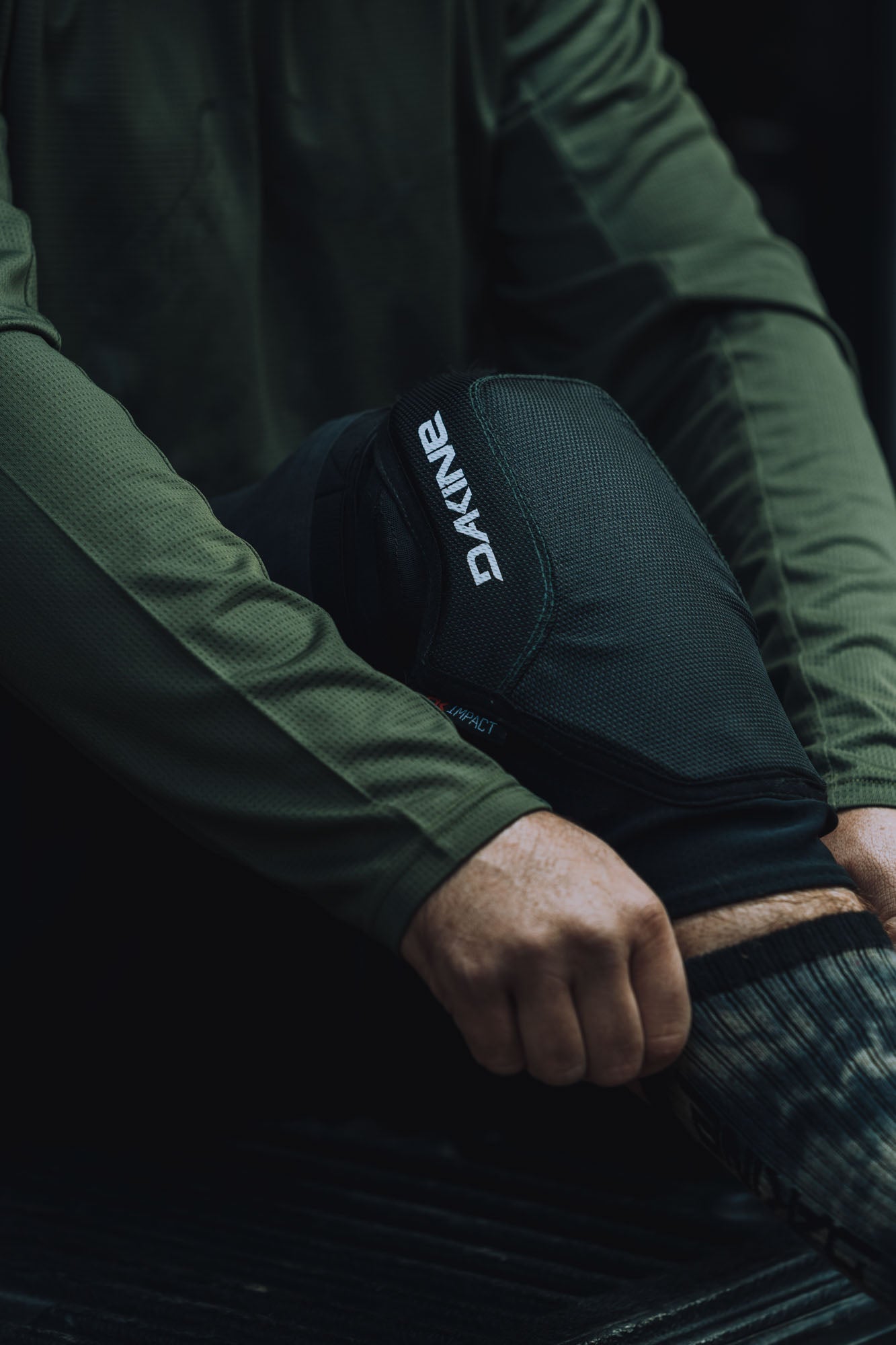 DAKINE black knee pad worn on person's knee in action pose