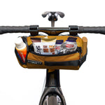Almsthre Signature Bar Bag in California Gold mounted on bike handlebars with snacks
