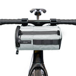 Gray ALMSTHRE handlebar bag mounted on bicycle handlebars with attachment straps