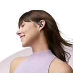 Woman wearing black Shokz OpenFit Air earbuds in profile, smiling