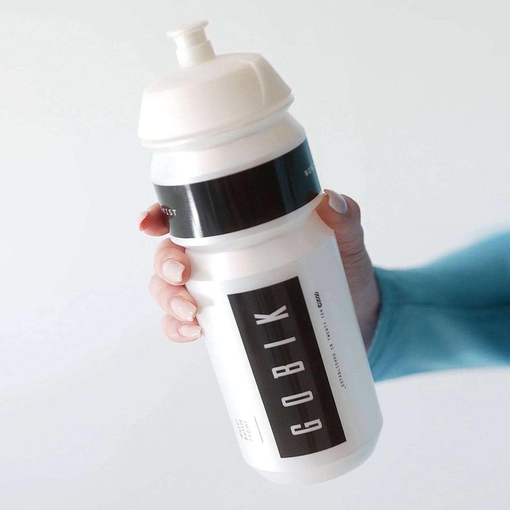 Gobik water bottle in white with black logo bands held by hand