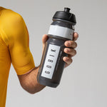 Gobik Shiva water bottle in shadow grey held by person in yellow athletic wear