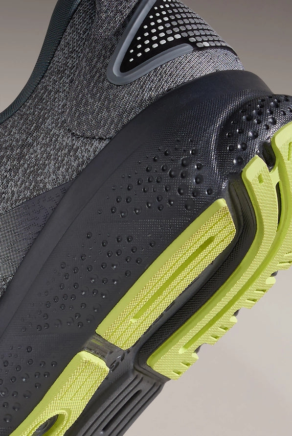 Close-up of Brooks Ghost 16 running shoe showing grey upper and lime green sole details