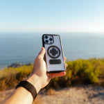 Hand holding Rokform Crystal Case for iPhone with circular mount in outdoor setting