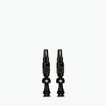 Two black Muc-Off Big Bore Lite tubeless Presta valves on white background