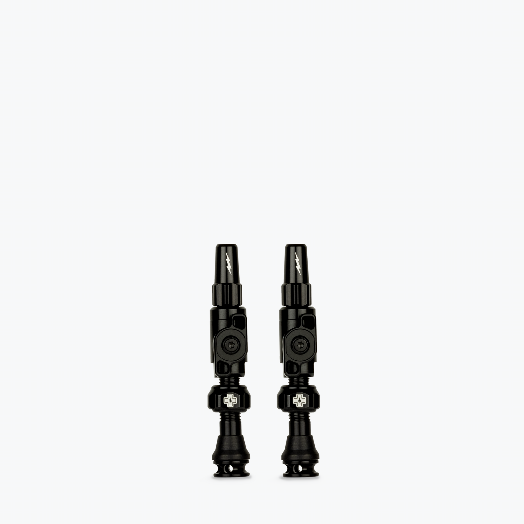 Two black Muc-Off Big Bore Lite tubeless Presta valves on white background