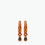 Two orange Muc-Off Big Bore Lite Tubeless Presta Valves on white background