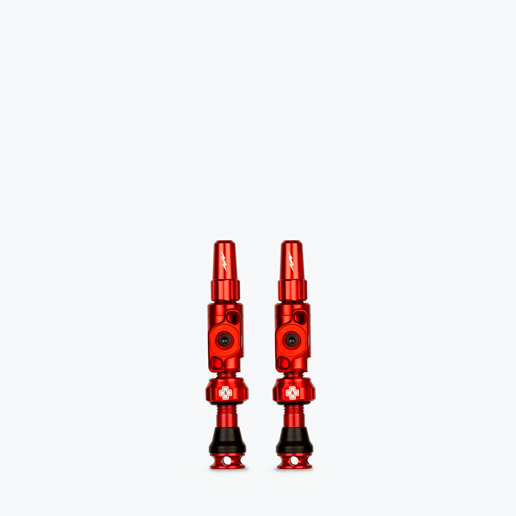 Pair of red Muc-Off Big Bore Lite tubeless Presta valves on white background