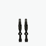 Two black Muc-Off Big Bore Lite tubeless Presta valves on white background