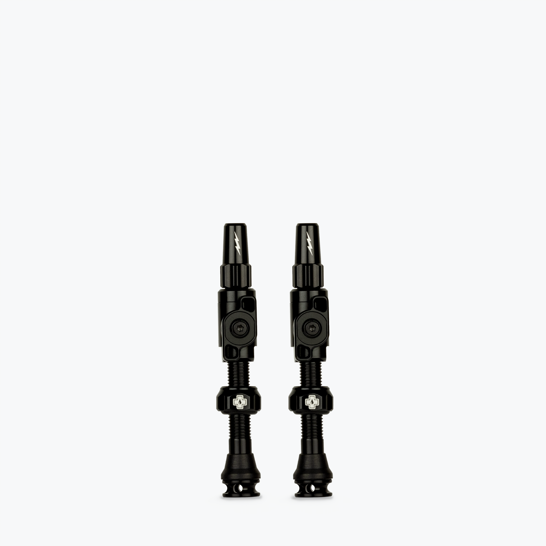 Two black Muc-Off Big Bore Lite tubeless Presta valves on white background