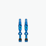 Two blue Muc-Off Big Bore Lite tubeless Presta valves on white background