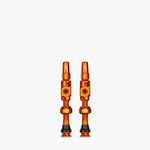Two orange Muc-Off Big Bore Lite tubeless Presta valves on white background