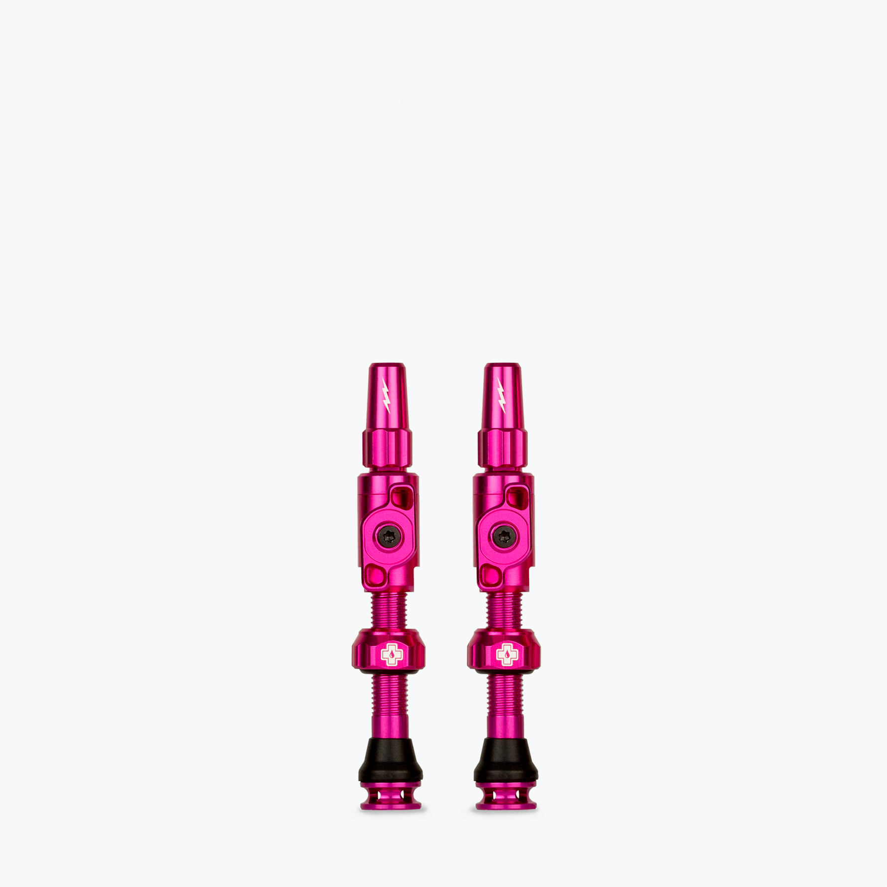 Two bright pink Muc-Off Big Bore Lite Tubeless Presta Valves on white background