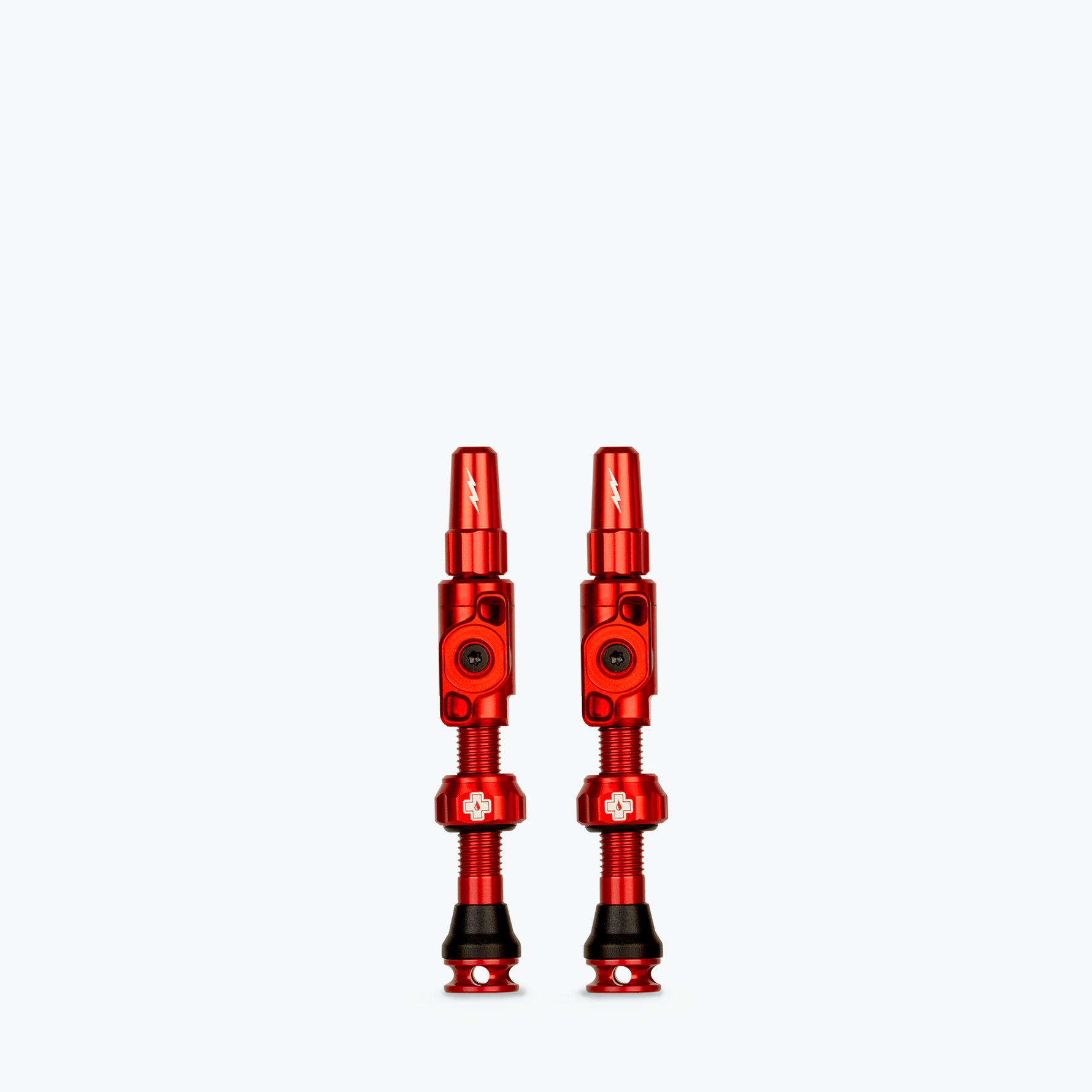 Two red Muc-Off Big Bore Lite tubeless Presta valves on white background