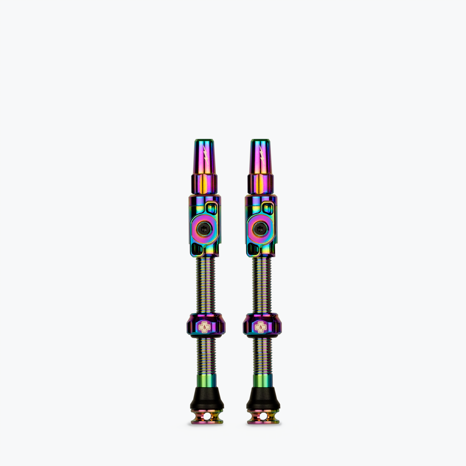 Two Muc-Off tubeless presta valves with rainbow iridescent finish on white background