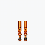 Two orange Muc-Off Big Bore Hybrid Tubeless Presta Valves on white background