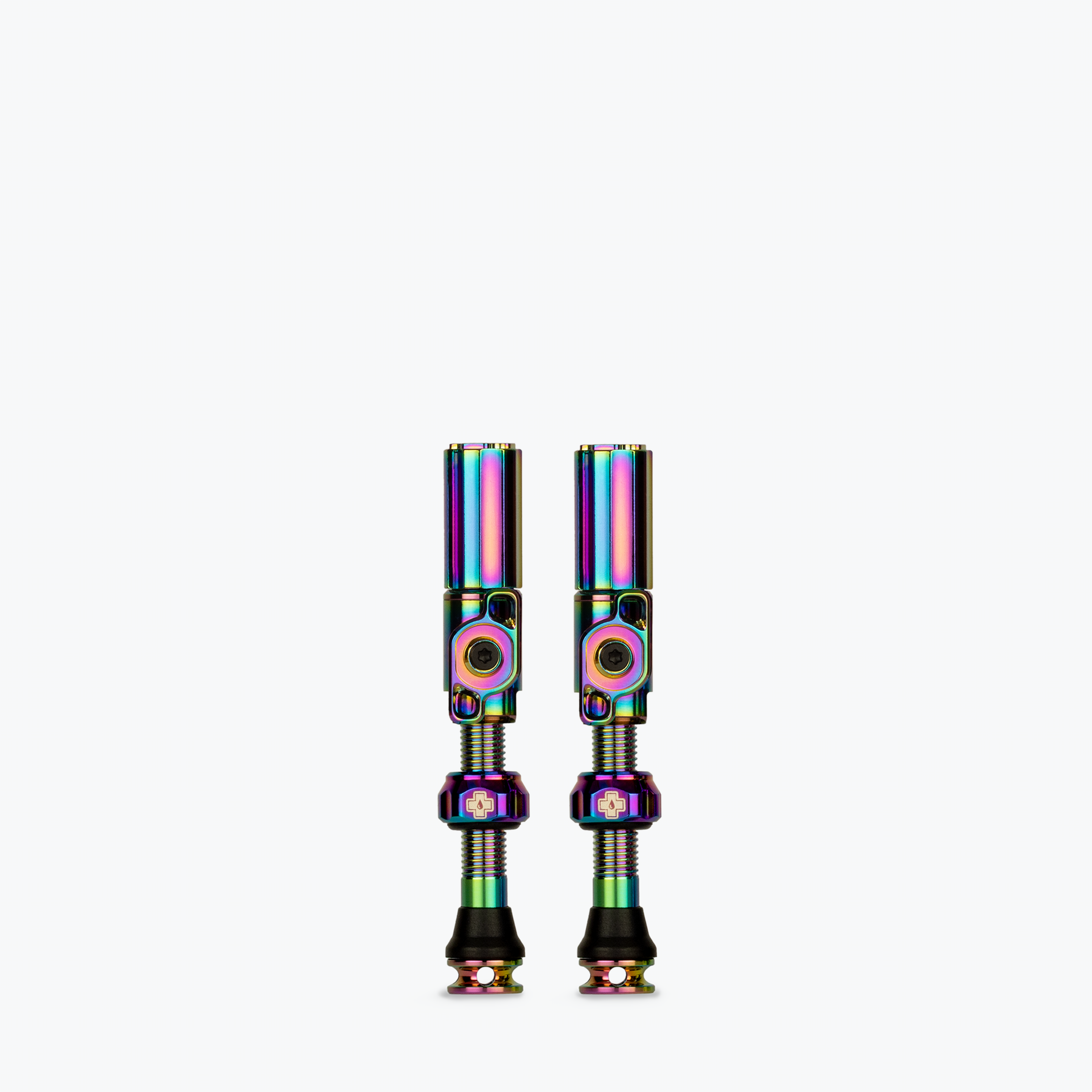 Pair of Muc-Off tubeless presta valves with rainbow iridescent coating on white background