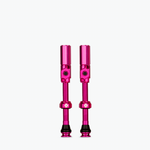 Two pink Muc-Off tubeless presta valves on white background