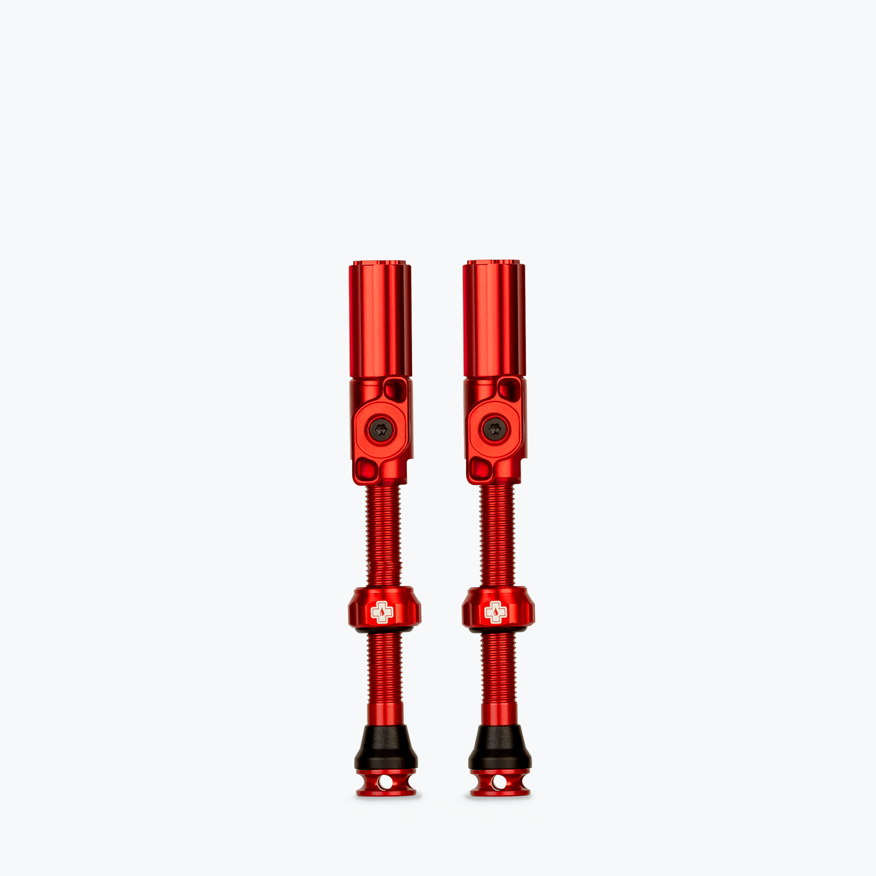 Pair of red Muc-Off tubeless presta valves on white background