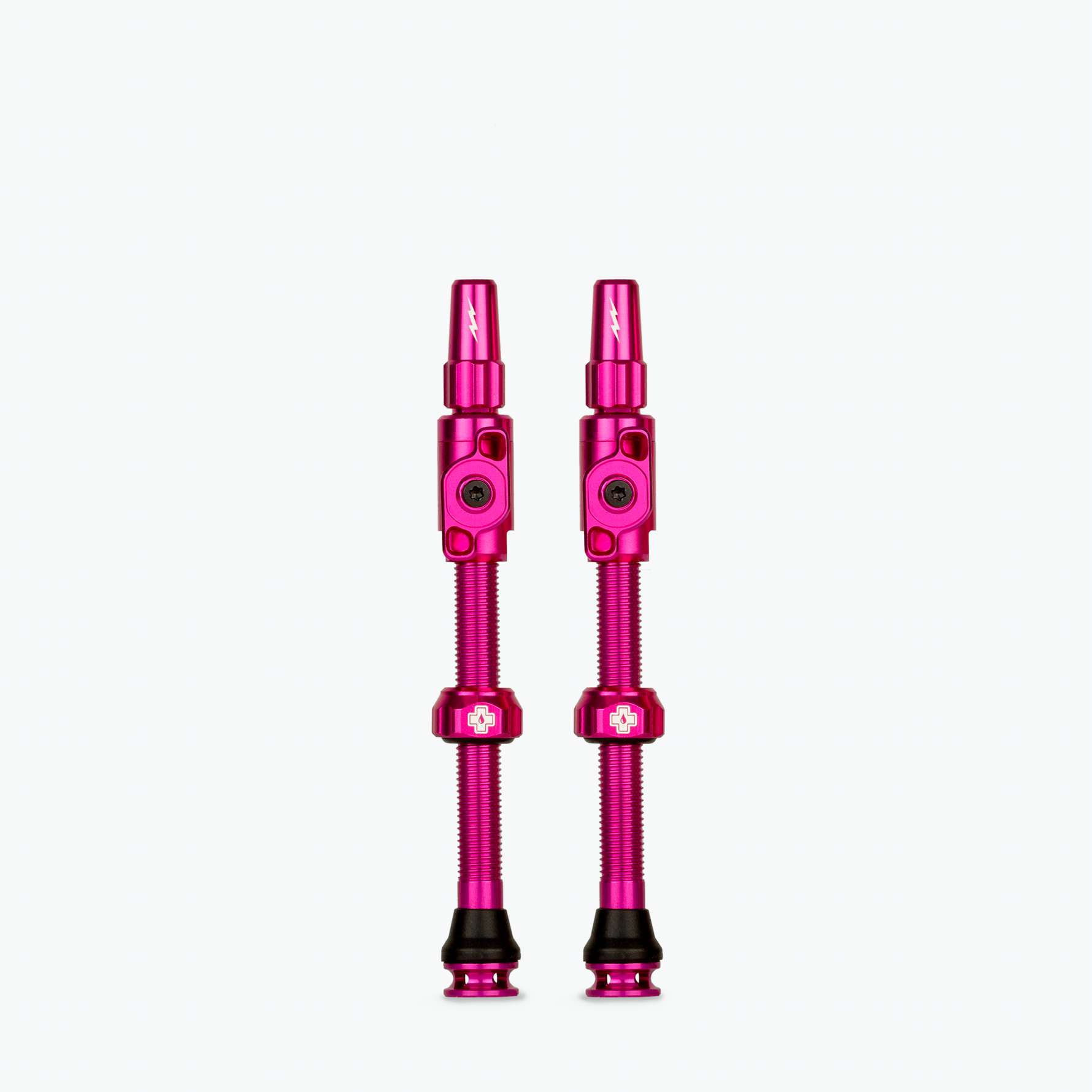 Two pink Muc-Off Big Bore Lite tubeless Presta valves on white background