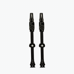 Two black Muc-Off Big Bore Lite tubeless Presta valves on white background