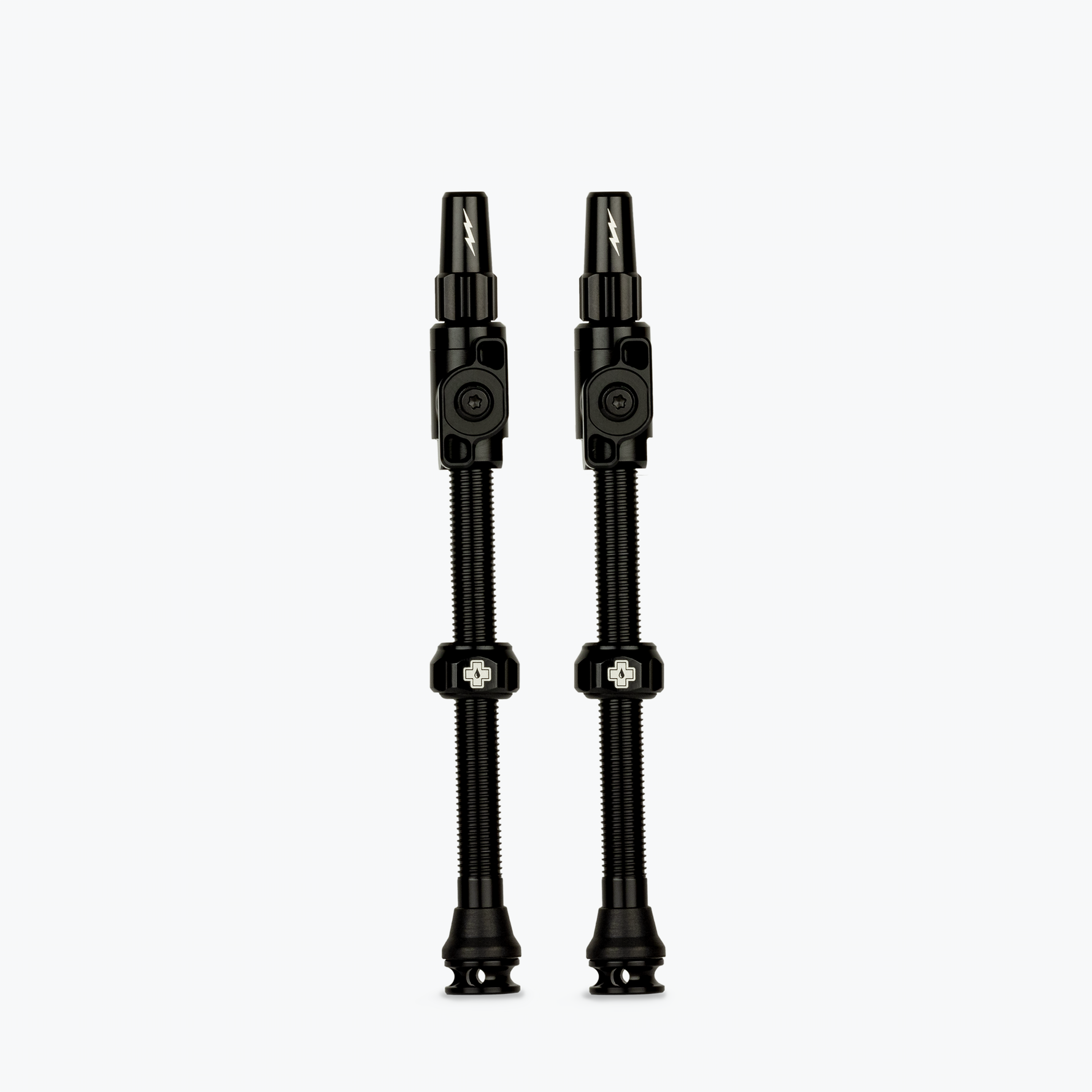 Two black Muc-Off Big Bore Lite tubeless Presta valves on white background