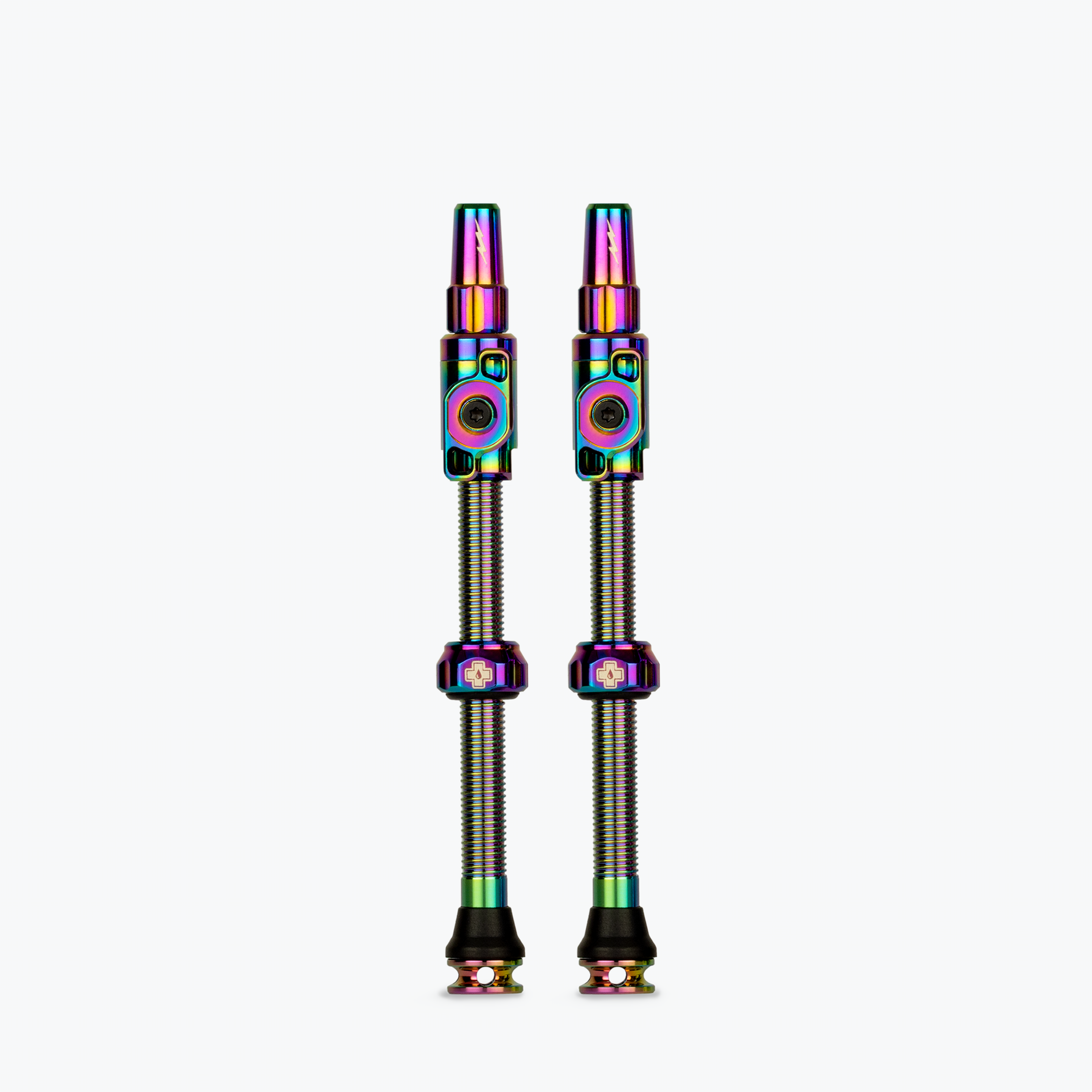 Two Muc-Off tubeless presta valves with rainbow iridescent finish on white background