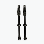 Two black Muc-Off Big Bore Lite tubeless Presta valves on white background
