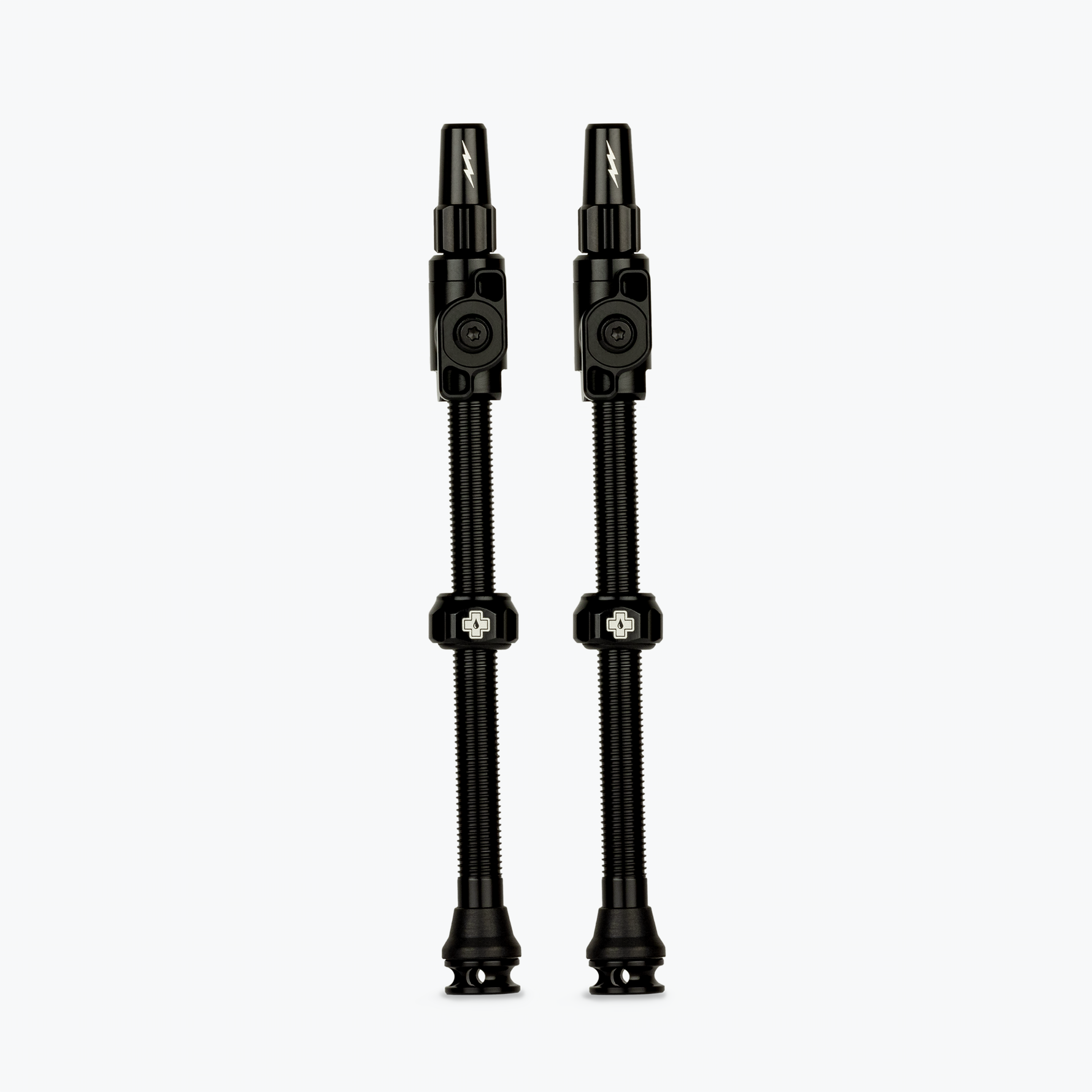 Two black Muc-Off Big Bore Lite tubeless Presta valves on white background