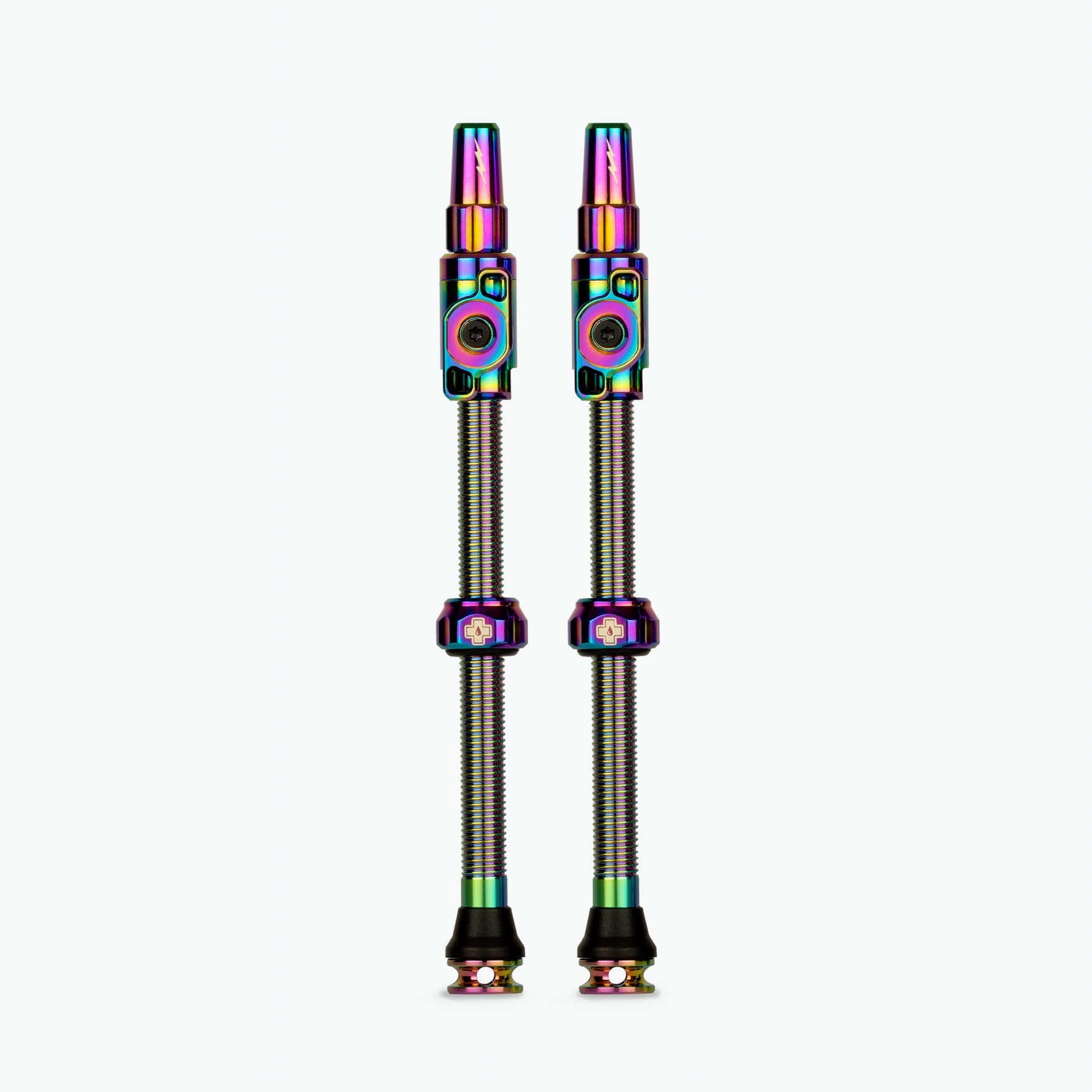 Two Muc-Off tubeless presta valves with iridescent rainbow finish on white background