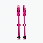 Pair of pink Muc-Off Big Bore Lite tubeless Presta valves on white background