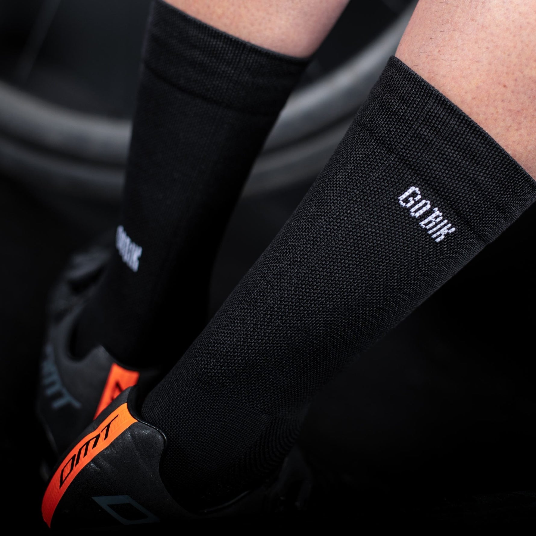 Black Gobik cycling socks with white logo worn by cyclist
