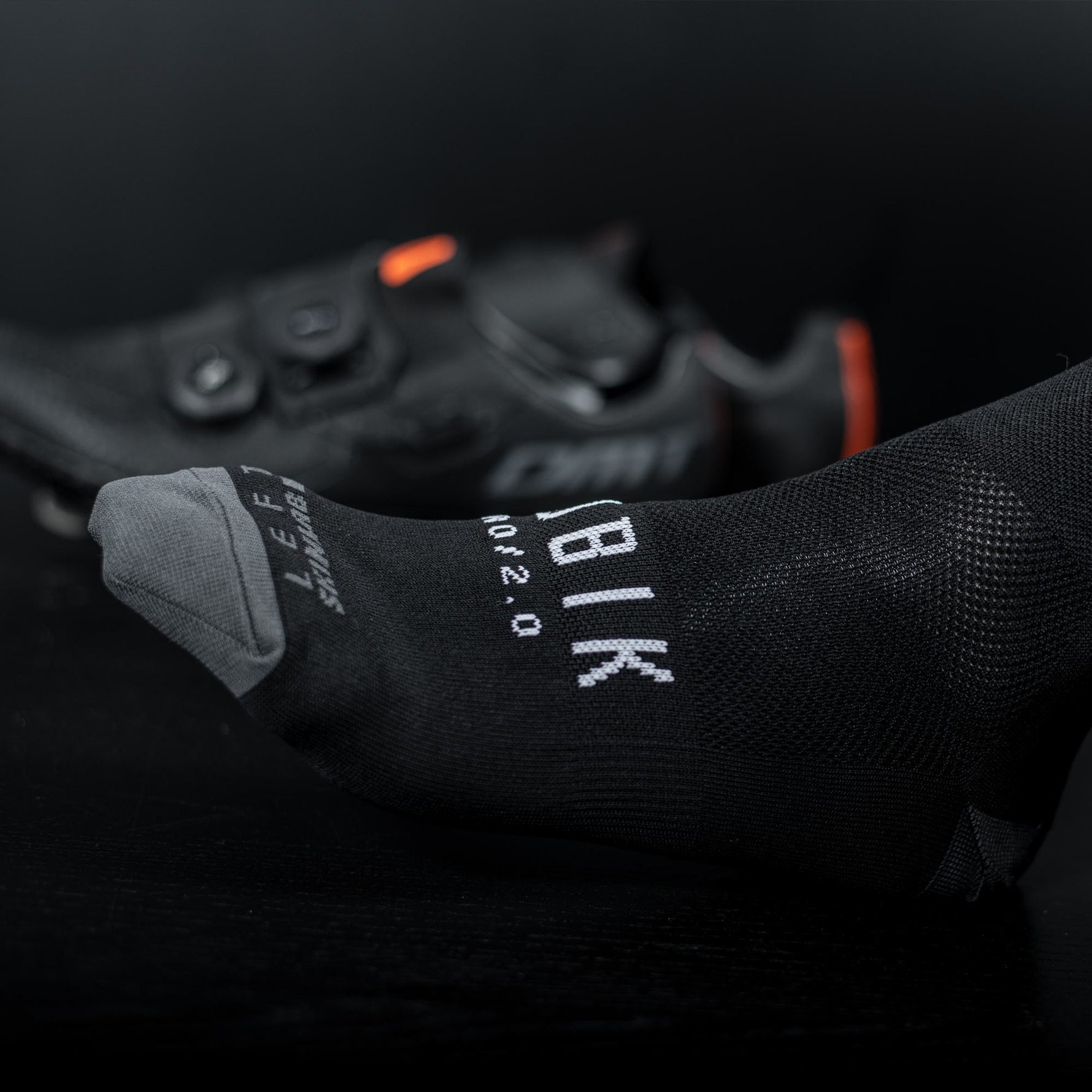 Black Gobik cycling socks with white logo text and mesh ventilation panels