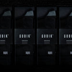 Four pairs of black Gobik socks in professional product packaging