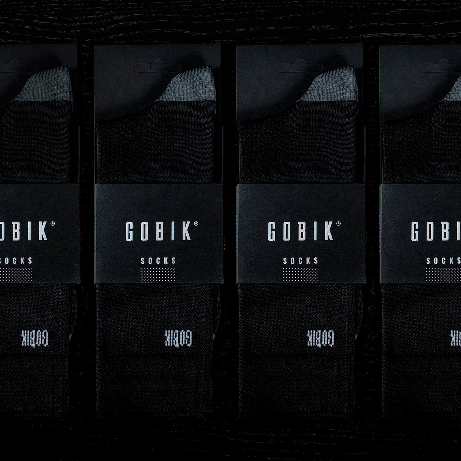 Four pairs of black Gobik socks in professional product packaging