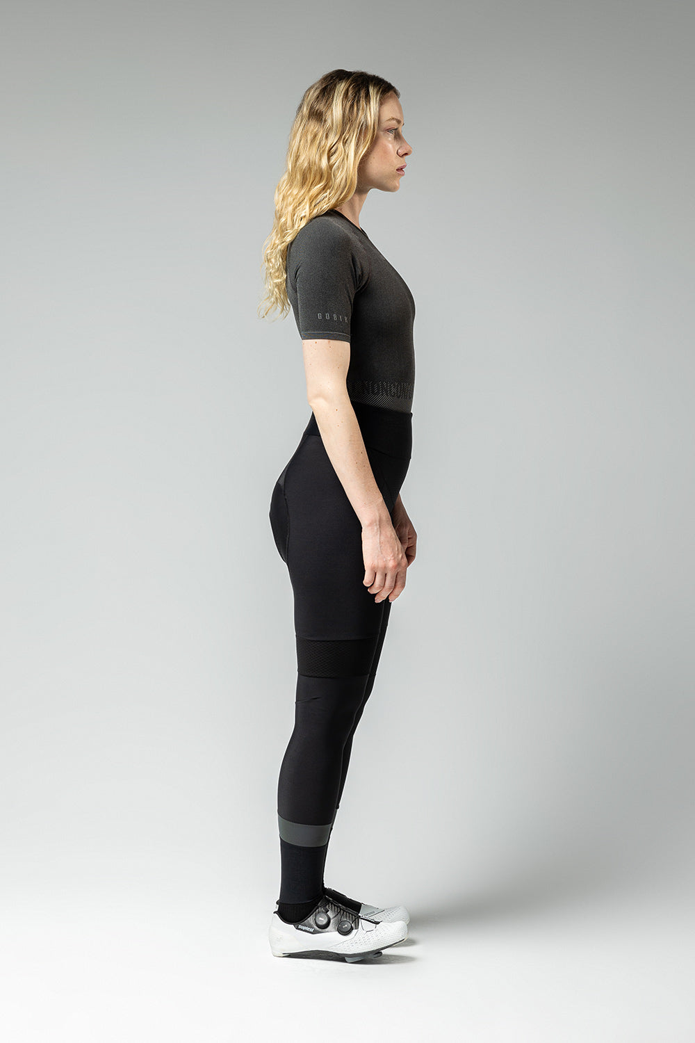 Woman wearing Gobik Limber base layer in basalt gray, side profile view