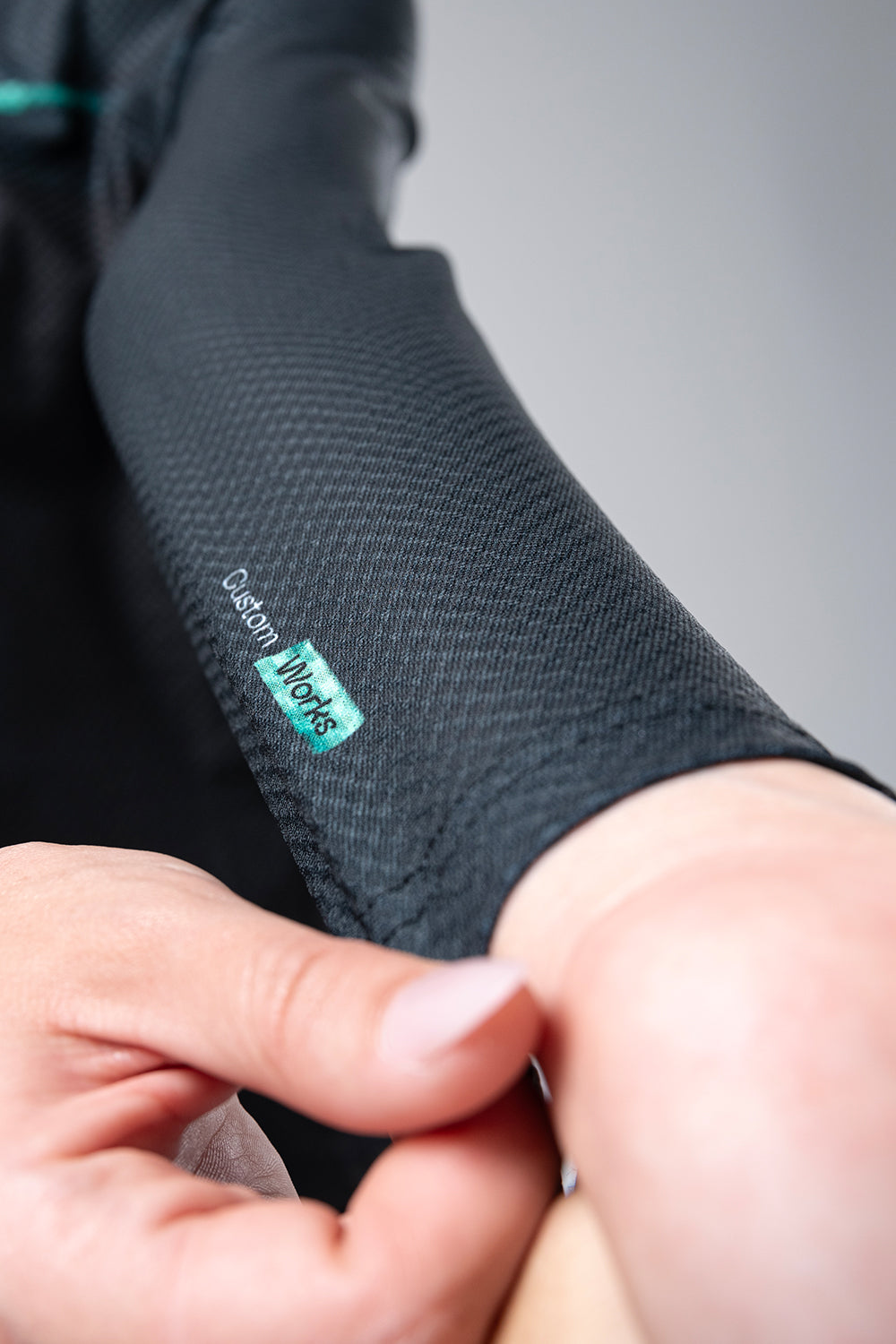Close-up of Gobik long sleeve shirt showing textured gray fabric and brand label detail
