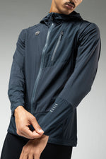 Man wearing Gobik navy blue lightweight rain jacket with hood and zip pockets