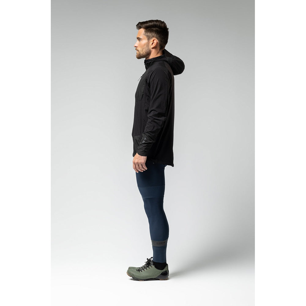 Man wearing black Gobik lightweight rain jacket with hood, side profile view