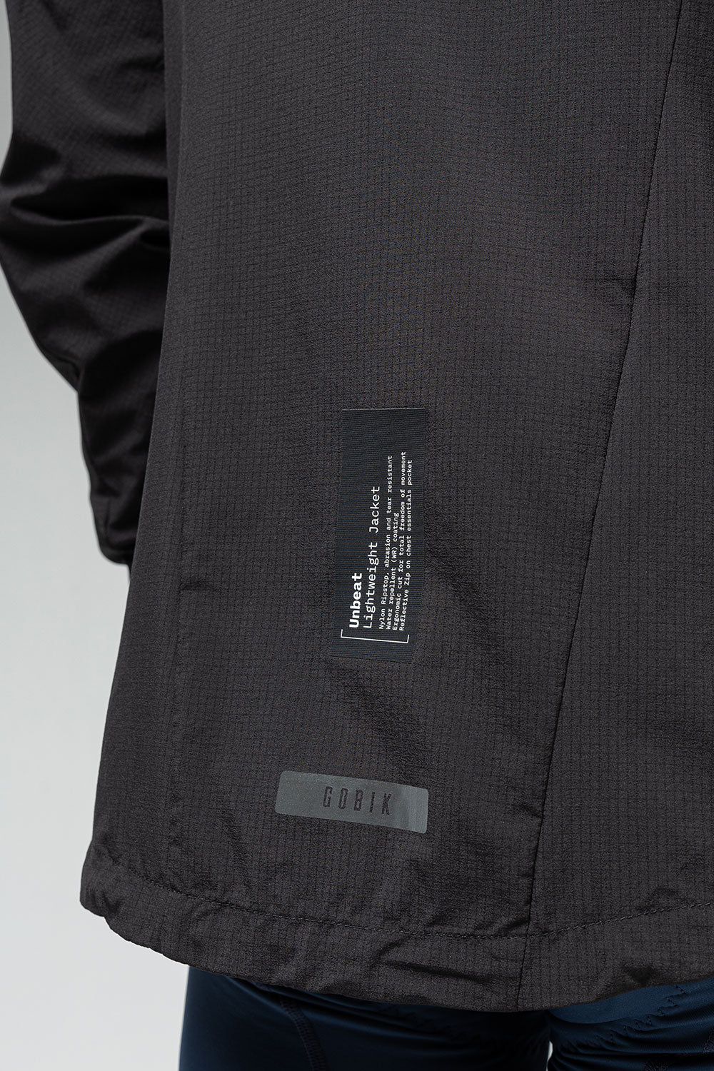 Gobik Unbeat lightweight rain jacket detail showing brand labels and fabric texture