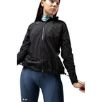 Woman wearing black Gobik lightweight rain jacket with blue cycling tights