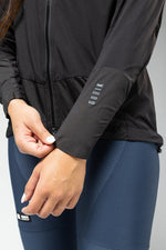 Woman wearing black Gobik lightweight rain jacket with zipper and sleeve branding