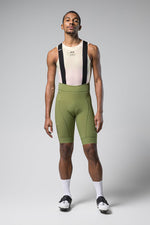 Gobik Matt Men's Bibshort in olive green with black suspenders on model