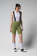 Woman wearing Gobik Matt 2.0 Bib Shorts in olive green with white mesh top