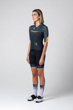 Woman wearing Gobik CX Pro cycling jersey in dark grey with orange details