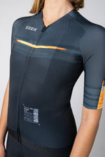 Gobik CX Pro cycling jersey in dark navy with orange accents on model