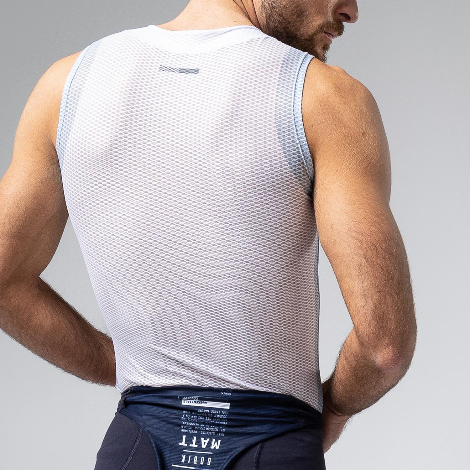 Man wearing white Gobik Second Skin mesh base layer tank top